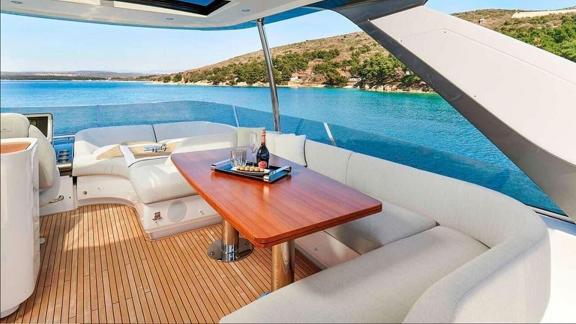 Ein Holztisch mit Getränken und Polstersitze bieten Genuss mit Meerblick.