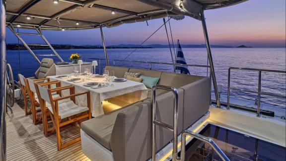 The flybridge of Adara yacht offers an elegant setting for dining and relaxing at sunset.