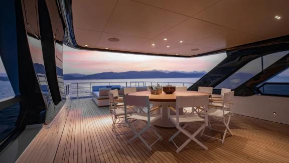 Elegant alfresco dining area on Dawo motor yacht during sunset, anchored in scenic Sibenik waters.