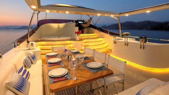 Archsea motoryatın flybridge alanında gün batımı manzarası eşliğinde akşam yemeği sunuluyor.
