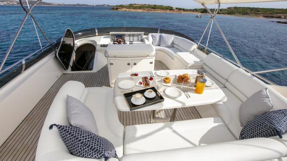 A breakfast table with a sea view is set on the upper deck of the yacht Azure.