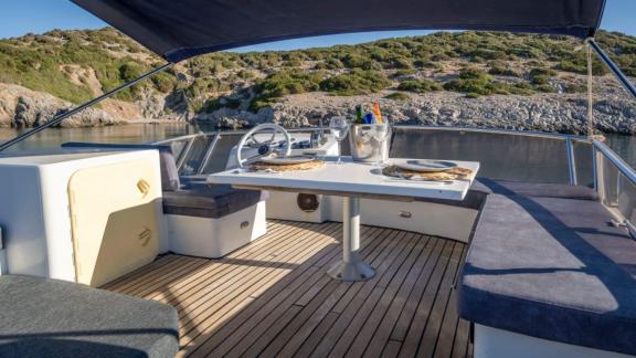 Dining area on the upper deck of motor yacht Moonlight, with nature in the background.