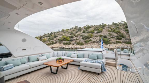 Anchored near Athens, the flybridge offers cushioned sofas, a table and jacuzzi with scenic views.