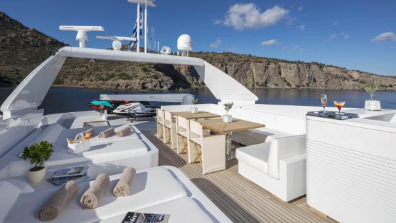 Entspannendes Sonnendeck mit Liegestühlen und Tischen auf der Sole Di Mare in Griechenland.