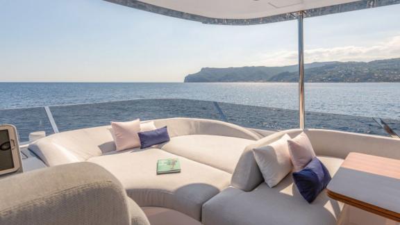 Relaxing sun lounger with cushions and a wide view of the sea and coast.