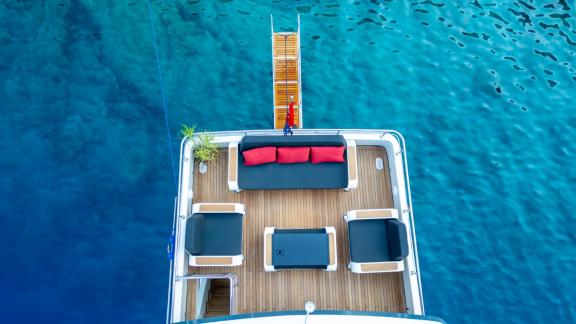 The upper deck of trawler yacht Kaan Bey 2 features a cozy seating area with a sea view.