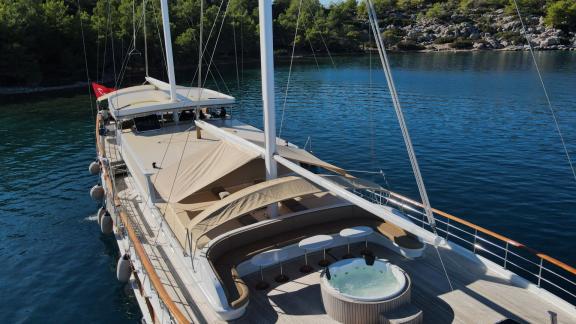 Gulet-Yacht mit geräumigem Deck und Whirlpool in einer ruhigen Bucht.