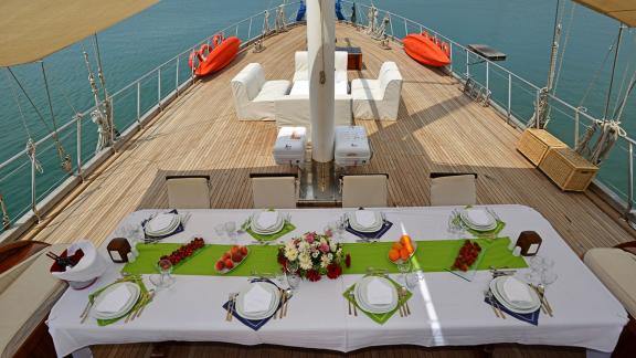 A festively laid dining table on the deck of the 10-cabin Gulet Holiday X, ready for an elegant dinner in Fethiye.