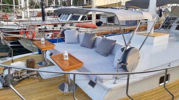 Cozy seating area with cushions and small tables on the foredeck of Gulet Simi, perfect for dockside stays.