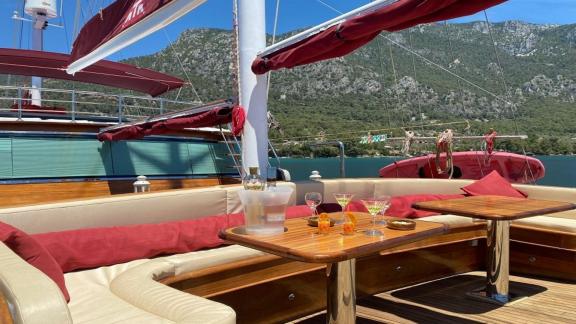 Komfortabler Sitzbereich auf der Gulet Mrs. Elcih in Göcek, Türkei, mit Getränken und schöner Aussicht.