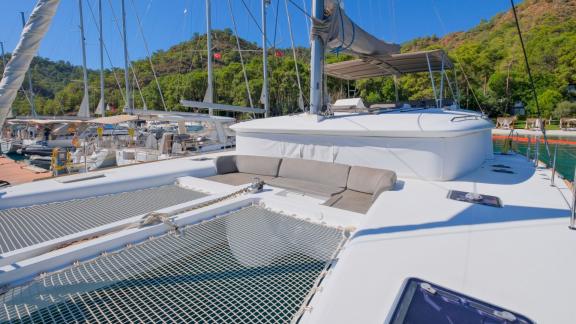 Katamaran Kokopelli liegt im Yachthafen von Göcek, mit Fokus auf die Vordeck-Sitzgruppe.