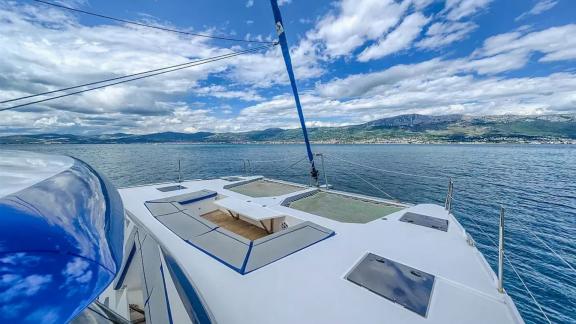 Luna 49 Blue katamaranın ön güvertesi, deniz üstü ağ alanı ve minderli oturma bölümüyle Split manzarasına açılıyor.