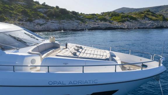 Sunseeker 75 features plush sunbeds on its bow, anchored near the rocky shores of Split.