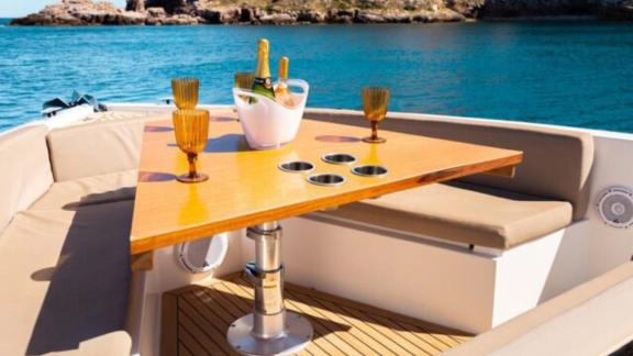 Comfortable seating area on the foredeck of motor yacht Cea 3, featuring champagne and glasses.