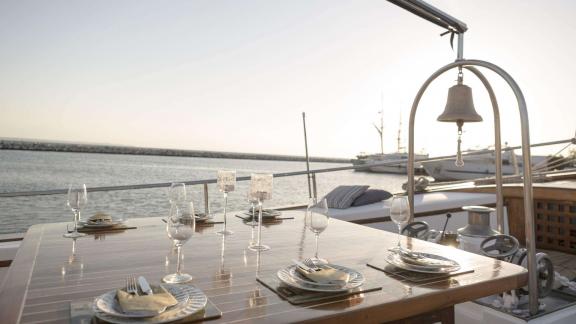 A beautifully set table on the deck of Cosmos at sunset.