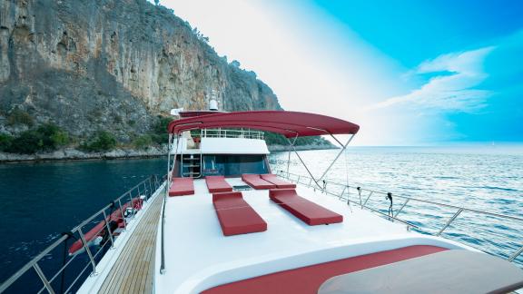 Enjoy the sun deck of Ok Ay with comfortable loungers and breathtaking views of the sea and cliffs.