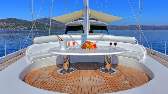 Angelo 2 motorsailer offers a cozy seating and dining area on the foredeck with a peaceful sea view.