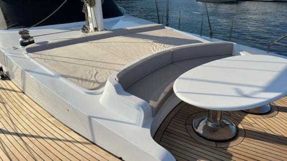 On the foredeck of Angelo 3, a relaxing corner with seating and a round table.