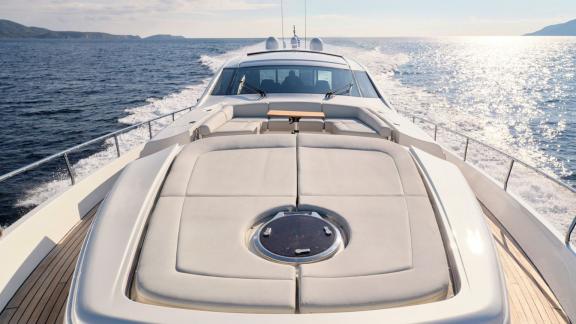 The For Ever yacht speeds over the open blue waters with a spacious sunbathing area in the front.