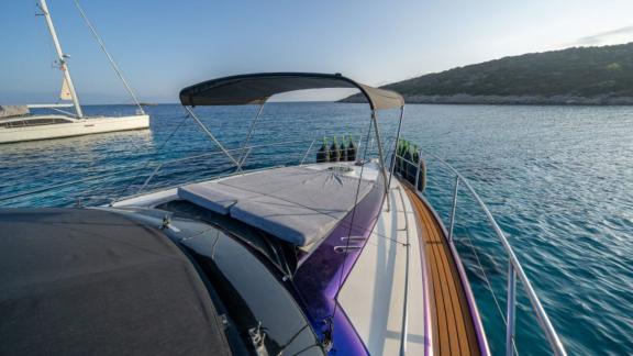 The foredeck of Karan motor yacht features sun pads and a shaded area for a comfortable experience.