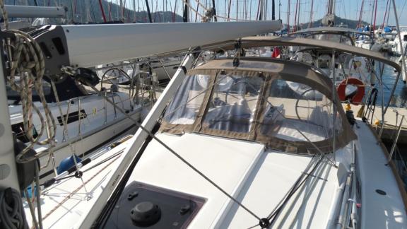 The foredeck of Sarita with a bimini top and sail rigging is visible.