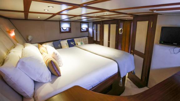 Gazella’s master cabin features a large bed, seating area, wardrobes, and a TV.