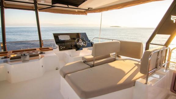 The Power 67 Ariva offers a flybridge helm station with panoramic views and golden light over Corfu’s sea.