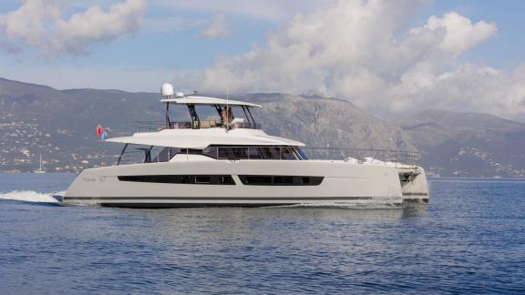 The Fountaine Pajot Ariva glides through calm waters with Corfu’s mountain backdrop in the distance.