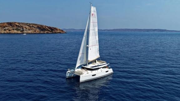 Helidoni charter catamaran glides through the blue waters off Volos.