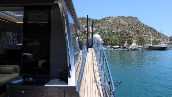 Deck of motor yacht Fundamental B with harbor view in the background.