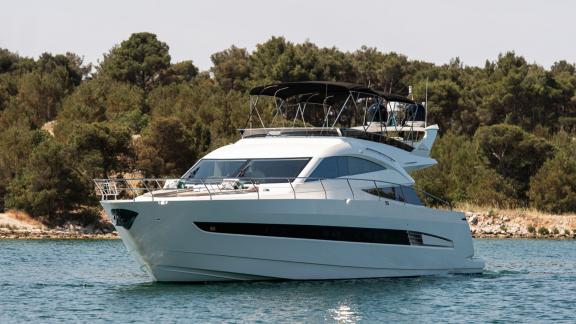The sleek Le Chiffre yacht cruises peacefully along the scenic coastline of Šibenik, Croatia.