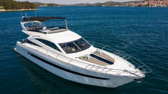 A sleek white motor yacht sails through the crystal-clear waters of sunny Šibenik, Croatia.