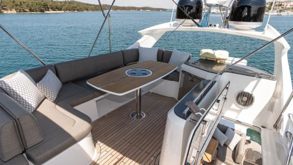 Spacious cushioned seating and table on Le Chiffre’s flybridge, anchored in Šibenik.