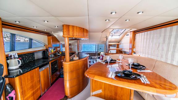 Dining and kitchen area of the Edition yacht with stylish and functional interior, featuring large glass windows with a