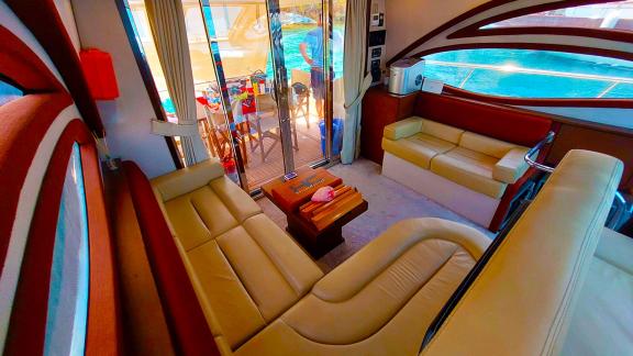 The saloon area of motor yacht Germanor offers a relaxing atmosphere with comfortable seating and large glass doors.