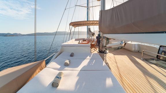 In Göcek gulet charter option Getaway deck with sunbeds open sea view and spacious lounging area visible.