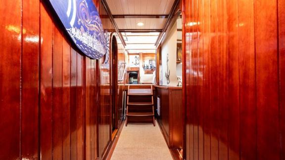 Shiny wooden hallway with access to the salon and cabins on Gulet Golden Joy in Bodrum.