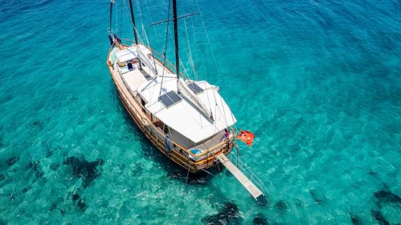 Die Gulet Golden Joy ankert im klaren türkisfarbenen Wasser, ideal für einen entspannten Urlaub in Bodrum.