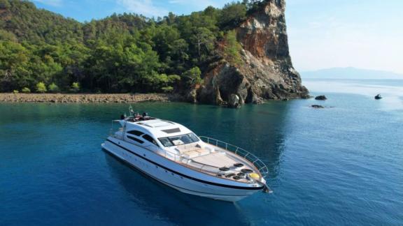 Stylish motor yacht in the tranquil bay off the green coast of Greece.