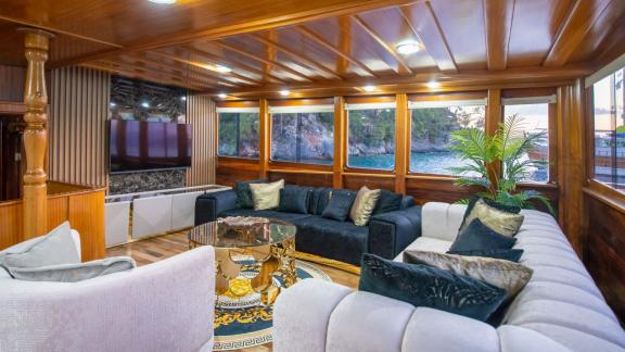 Comfortable lounge area in the Grand Acar Gulet with panoramic windows in Fethiye.