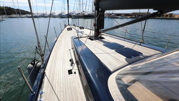 Spacious teak foredeck of the Morfely sailing yacht in a Sardinia marina, Italy. Ideal for yacht charter holidays.