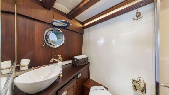 Modernes Badezimmer auf der Gulet-Yacht Jasemin 1 mit stilvollem Waschbecken und Rundfenster.