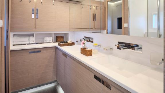 Elegant bathroom on the catamaran with a large mirror, spacious cabinets, and modern fixtures.