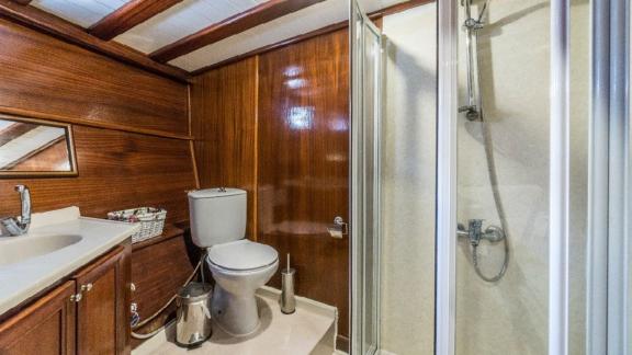 Bathroom with toilet, sink, and shower cabin on the Gulet Optimist in Bodrum.