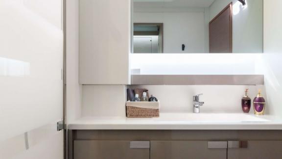 Stylish sink with illuminated mirror and toiletries in a catamaran bathroom.