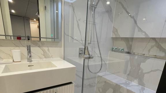 Stylish bathroom with a glass shower and marble design in the Genny catamaran, offering modern comfort.