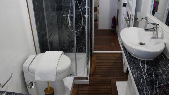 Elegantes Badezimmer der Grande Mare mit Dusche, stilvollem Waschbecken und hochwertigen Armaturen.