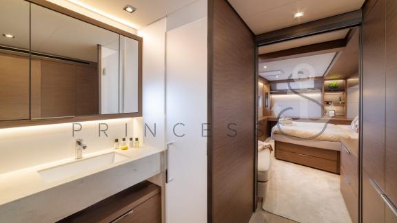 Stylish bathroom with large mirror and direct access to the luxurious cabin aboard a Princess S Yacht