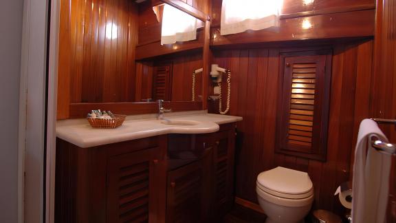 Comfortable twin cabin on the Sunworld 8 with soft lighting and wood paneling.