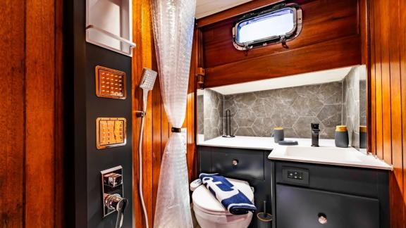 Stylish bathroom with shower, sink, and porthole on Gulet Golden Joy in Bodrum.